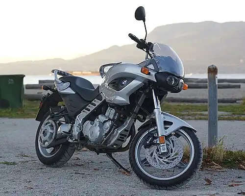 Silver BMW F650CS parked on brick paving