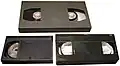 A size comparison between Betacam SP L (top), Betacam SP S (bottom-left), and VHS (bottom-right)