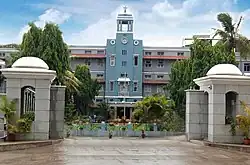 Three-story building with central column, framed with palm trees