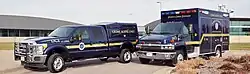 Two vehicles belonging to the DCI Crime Scene Unit staged outside of DCI headquarters.
