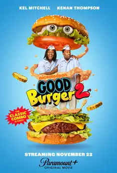 A giant-sized buger, with two fast food workers standing in the middle.