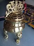 A large urn located in front of the gate at the temple.
