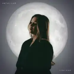A photograph of Ajax standing and turned to the side in front of the moon