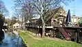 View along the banks of the Wandle, with the watermill at the rear