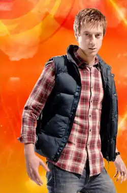 The blond Rory wars a black vest over a red checkered patterned shirt.