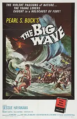 A boy clutches a girl's wrists frantically in shallow water, followed by villagers watching horrified as a massive wave crashes toward their seaside village. A volcano erupts in the background, lighting up the horizon.
