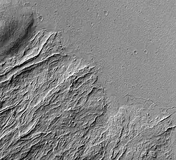 Image shows both young and old lava flows from the base of Olympus Mons. The flat plain is the younger flow. The older flow has channels with levees along their edges. The presence of levees is quite common in many lava flows.